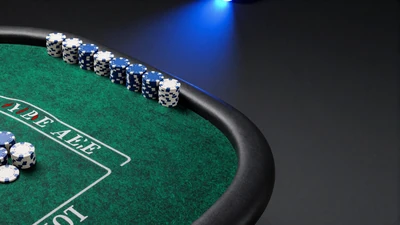 Gr&uuml;ne Filz-Tischkante mit blauen Casino-Jetons - Tischspiele bei Casea Casino